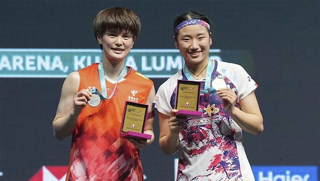 안세영(오른쪽)이 12일 말레이시아 쿠알라룸푸르에서 열린 세계배드민턴연맹(BWF) 월드투어 말레이시아오픈(슈퍼 1000) 여자단식에서 우승한 뒤 결승전 상대였던 왕즈이(중국)와 함께 카메라 앞에 섰다. 쿠알라룸푸르=AP 뉴시스