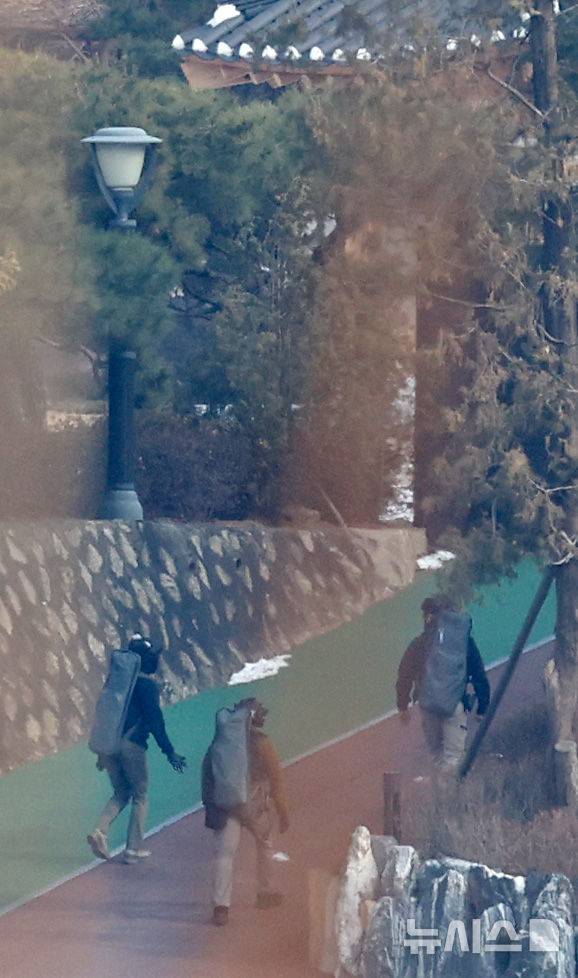 [서울=뉴시스] 김선웅 기자 = 윤석열 대통령에 대한 공수처와 경찰의 2차 체포영장 집행 시도가 임박한 12일 서울 용산구 한남동 대통령 관저에서 전술복과 헬멧을 착용한 경호처 관계자들이 이동하고 있다. 2025.01.12. mangusta@newsis.com