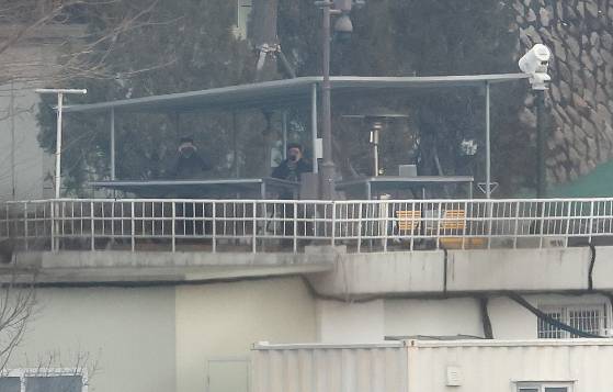 경호처 요원들이 망원경으로 부지 밖 상황을 살피고 있다. 뉴스1