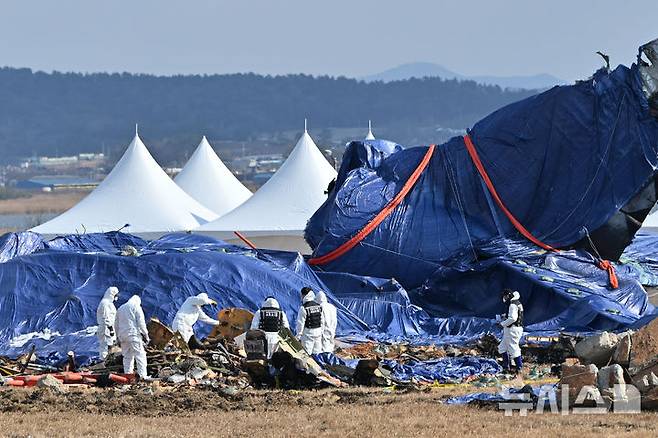 [무안=뉴시스] 이영주 기자 = 국토교통부 항공철도사고조사위원회 소속 감식반이 지난 8일 오전 전남 무안군 무안국제공항 내 제주항공 여객기 참사 현장에서 사고 여객기 잔해물을 수거하고 있다. 2025.01.14. leey2578@newsis.com