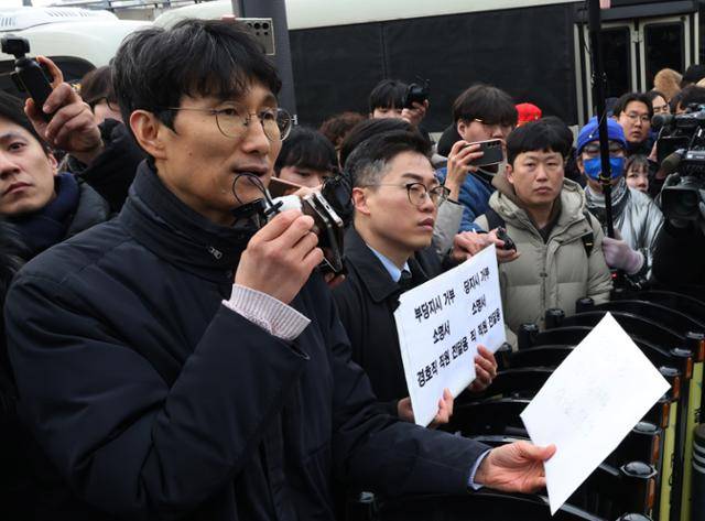 차성안 서울시립대 법학전문대학원 교수가 13일 오후 서울 용산구 한남동 관저 앞에서 경호처 관계자에게 부당지시거부 소명서 전달에 앞서 경호처 직원과 가족용 법률상담 7문 7답 질문지를 읽고 있다. 연합뉴스