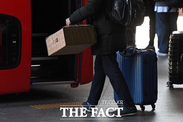 서울 서초구 서울고속버스터미널에서 한 귀성객이 명절 선물을 들고 버스에 탑승하기 위해 이동하고 있다. /더팩트 DB