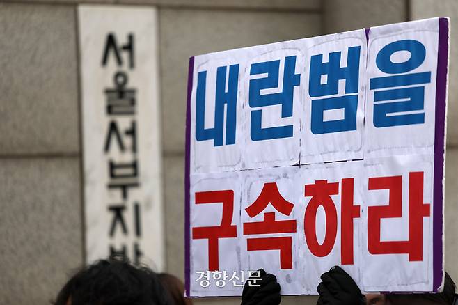 기자회견에 참석자가 윤석열 대통령의 구속을 촉구하는 손팻말을 들고 있다.