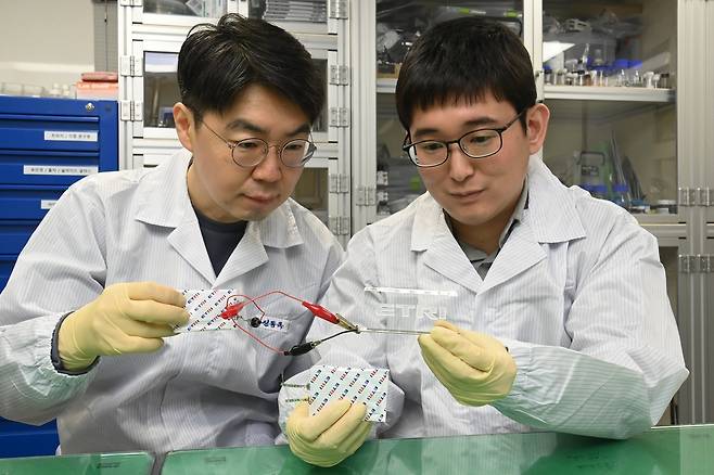 ETRI연구진이 초박막 고체전해질막이 적용된 파우치형 전고체 이차전지를 통해 LED를 구동하고 있다.[ETRI 제공]