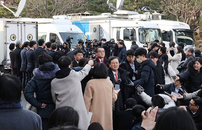 윤석열 대통령의 탄핵심판 첫 변론기일인 2025년 1월14일 오후 탄핵소추단(왼쪽 등지고 선 이들)과 윤갑근 변호사(가운데 발언하는 이) 등 윤석열 대통령 변호인단이 서울 종로구 헌법재판소에서 변론을 마친 뒤 각각 입장을 밝히고 있다. 한겨레 신소영 기자&nbsp;