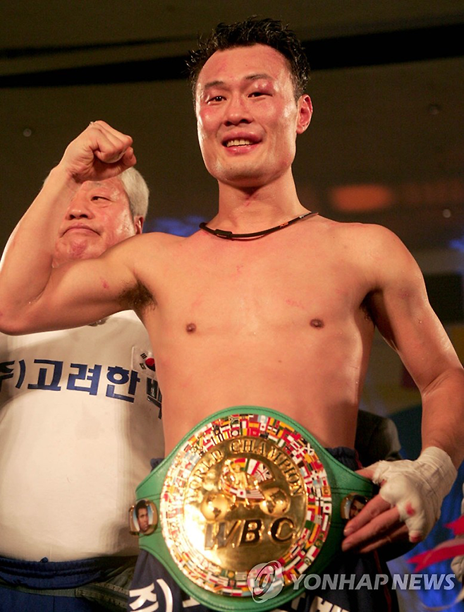 지인진이 2006년 12월 도전자로 참가한 세계복싱평의회 페더급 타이틀매치 만장일치 판정승으로 챔피언이 된 기념 촬영을 하고 있다. 사진=연합뉴스 제공
