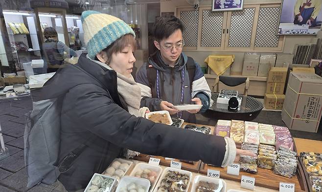 일본인 관광객 와타나베 가즈요(39·왼쪽)씨와 곤도 가즈야(31)씨가 지난 11일 서울 종로구 낙원떡집에서 떡을 살펴보고 있다. 김동환 기자