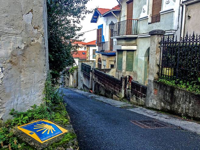 The yellow scallop shell signing the way to santiago de compostela on the Major Christian pilgrimage route Camino de Santiago, the Way of Saint James, along the Northern coast of Spain