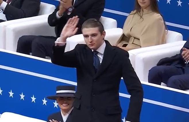 도널드 트럼프 미국 대통령의 막내 아들 배런 트럼프가 20일(현지시간) 워싱턴 캐피털 원 아레나에서 열린 실내 대통령 취임 퍼레이드 행사에 참석해 손을 흔들고 있다. [CNN]