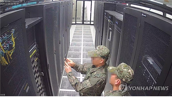 국회 행정안전위원회가 지난해 12월 3일 계엄령 선포 당시 선거관리위원회에 투입된 계엄군이 선관위 시스템 서버를 촬영하는 장면이 담긴 CCTV를 공개했다. [연합]