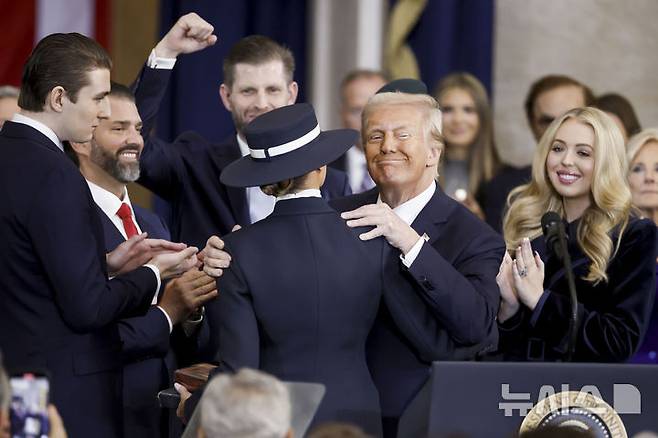 [워싱턴=AP/뉴시스] 도널드 트럼프 미국 대통령 당선인이 20일(현지 시간) 본인의 제47대 대통령 취임식이 열리는 미 연방의회 의사당 로툰다 홀에 입장해 앞서 입장한 부인 멜라니아 여사에게 입 맞추고 있다. 2025.01.21.