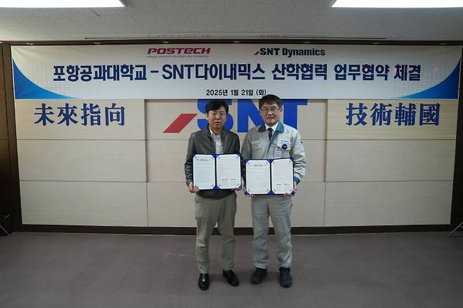 지난 21일 SNT다이내믹스 본사에서 열린 산학협력 MOU 체결식에서 김경태 포항공과대학교 국방과학기술협력센터장(왼쪽)과 박재석 SNT다이내믹스 대표이사가 업무협약서를 들고 포즈를 취하고 있다. SNT 제공