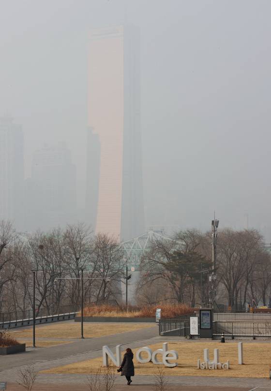 수도권과 충남에 올겨울 들어 처음으로 고농도 미세먼지 비상저감조치가 내려진 21일 서울 노들섬에서 바라본 63빌딩이 뿌옇게 보인다. 기상청은 오는 24일 동풍이 불면서 미세먼지가 물러날 것이라고 예보했다. [연합뉴스]