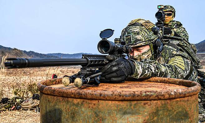 인공장애물을 활용한 가운데 해병대 특수수색대대 저격수가 K-14 조준경으로 표적을 조준하고 있다.