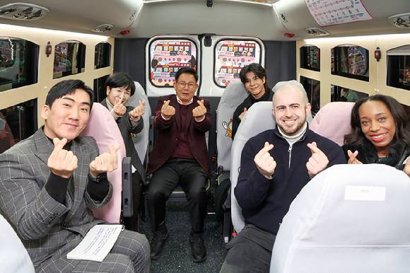 박강수 마포구청장(가운데)이 가수 정동원(중앙 오른쪽), 탑승객들과 마포순환열차버스 내부에서 기념촬영을 하고 있다. [사진=마포구청]