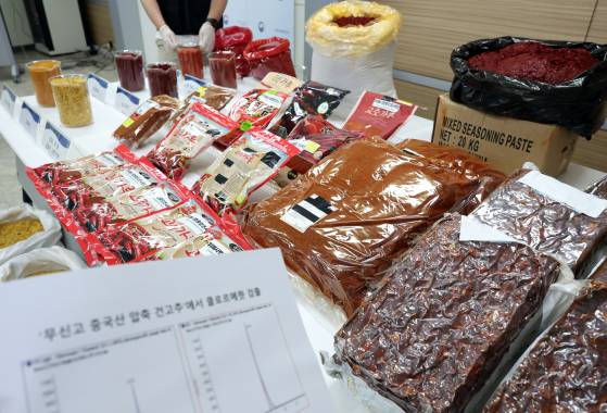 지난해 7월 서울 양천구 서울지방식품의약품안전처에서 식약처 수사관이 중국산 다대기와 고추씨 분말을 혼합한 향신료조제품을 건고추 100%의 고춧가루 등으로 속여 판매한 업자들에게서 압수한 가짜 고춧가루와 습다대기, 고추씨 등을 보여주고 있다. [연합뉴스]