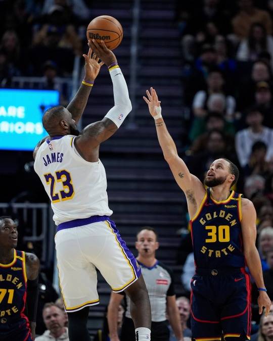 르브론 제임스가 미국 샌프란시스코에서 열린 NBA 농구 경기 후반전에서 골든스테이트 워리어스 스테판 커리를 제치고 슛을 던지고 있다. 사진[AP=연합뉴스]