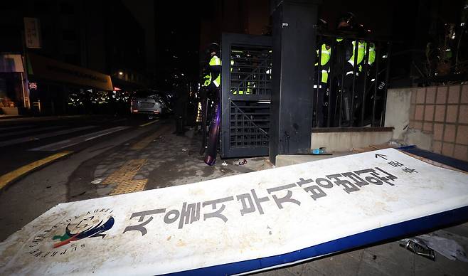 윤석열 대통령이 내란 우두머리 혐의로 구속되자 지지자들이 서울 마포구 서울서부지방법원에 난입한 1월19일 경찰이 서부지법 후문에 현판이 쓰러져 있다. ⓒ연합뉴스