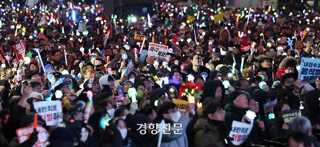 서울 여의도 국회 앞에서 열린 국민촛불대행진에 참석한 시민들이 지난해 12월14일 탄핵안이 가결되자 응원봉을 흔들고 있다. 권도현 기자