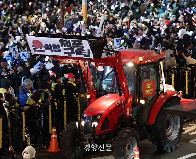 농민들이 몰고 온 트랙터가 지난해 12월22일 서울 한남동 대통령 관저 인근에서 시위를 벌이며 행진하고 있다. 트랙터는 서초구 남태령에서 경찰 차벽에 막혀 이틀 간 대치했으나 경찰이 차벽을 해제해 일부가 서울로 진입할 수 있었다. 권도현 기자