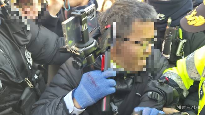 지난 2일 서울 용산구 한남동 대통령 관저 입구에서 경찰이 해산 요구에 불응하며 경찰에 저항하는 이모 씨. 경찰은 이날 농성 중이던 보수단체 회원 및 윤 대통령 지지자들에게 5차례에 걸쳐 해산 명령을 했다. 김도윤 기자.