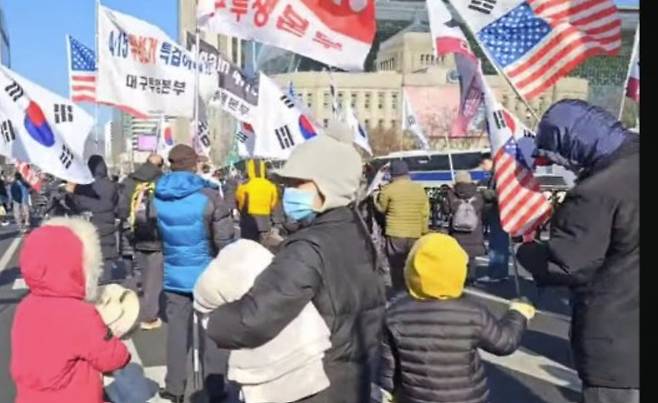 한 탄핵 반대 집회 현장에 참가한 어린이가 손에 성조기를 들고 있다.(커뮤니티 갈무리)