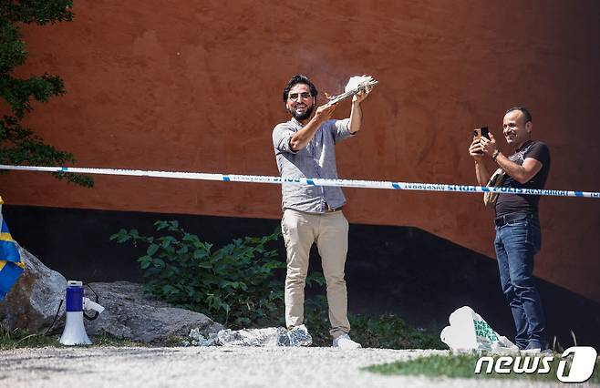이라크인 살완 모미카(37)가 28일(현지시간) 스웨덴 수도 스톡홀름의 한 모스크 앞에서 쿠란을 불에 태우고 밟는 시위를 벌였다. 스웨덴 당국은 '표현의 자유'라며 이를 승인했다. 2023.06.28/ ⓒ 로이터=뉴스1 ⓒ News1 박재하 기자