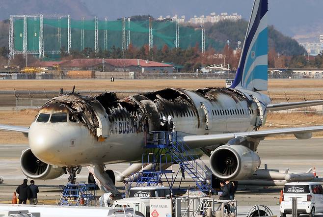 Authorities from the Aviation and Railway Accident Investigation Board, the Busan Metropolitan Police Agency, the Busan Fire Headquarters and the National Forensic Service conduct an on-site safety inspection of the Air Busan aircraft that caught fire late Tuesday, ahead of a joint forensic investigation scheduled later in the day at Gimhae International Airport in Busan, Thursday. (Yonhap)