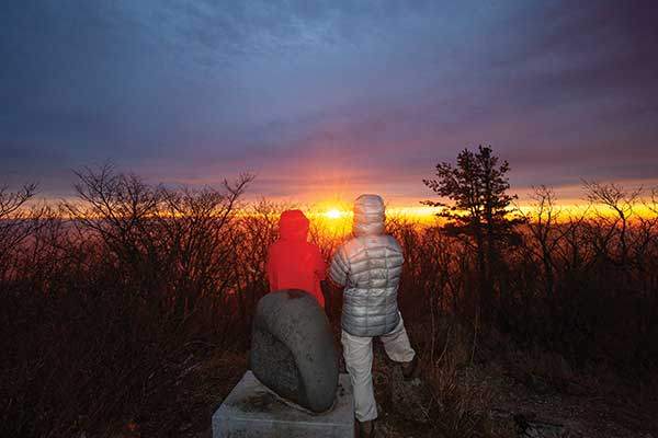 울진 백암산 정상에서의 일출. 정상석에 기대어 말없이 해가 떠오르는 장면을 지켜보았다. 순식간에 떠오른 해는 정상을 불타듯 붉은빛으로 물들였다.