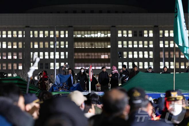 윤석열 대통령의 비상계엄 해제 요구 결의안이 국회 본회의에서 통과된 4일 새벽 서울 여의도 국회 정문 앞에 모인 시민들이 모여 있다. 2024.12.4/뉴스1 ⓒ News1 이재명 기자
