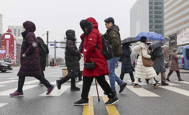 31일 서울 종로구 광화문네거리에서 시민들이 눈을 맞으며 출근길을 발걸음을 재촉하고 있다./임형택 기자