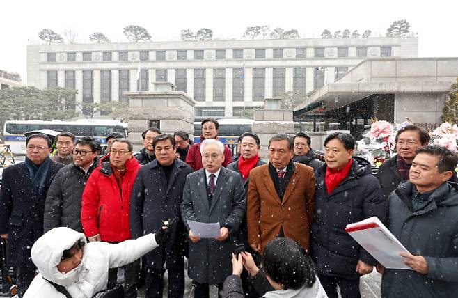 국민의힘 '탄핵반대 당협위원장 모임' 소속 위원장들이 지난달 31일 오후 서울 종로구 헌법재판소 앞에서 윤석열 대통령 탄핵 사건을 심리 중인 일부 재판관들의 정치적 편향성을 문제로 들며 재판관에 자진 사건 회피를 촉구하는 성명서를 낭독하고 있다. 연합뉴스