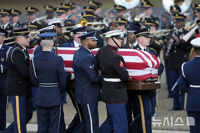 [플레인스=AP/뉴시스] 올해 1월 9일 성조기에 덮인 지미 카터 전 대통령의 유해가 조지아주 플레인스의 마라나타 침례교회로 운구되고 있다. 워싱턴 DC 국립 대성당에서 국가 장례식을 마친 카터 전 대통령의 관은 고향인 플레인스에서 개인 예배를 마친 후 부인 로잘린 여사 옆에 안장되었다. 2025.02.03.