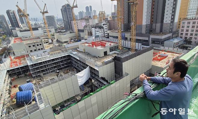 2022년 광주 서구 화정동 아이파크 붕괴 사고로 매형이 숨진 안정호 씨(희생자가족협의회 대표)가 지난해 11월 4일 재건설 현장을 바라보고 있다. 외벽이 붕괴된 201동이 있던 자리에 공사가 진행되고 있다. 광주=홍진환 기자 jean@donga.com