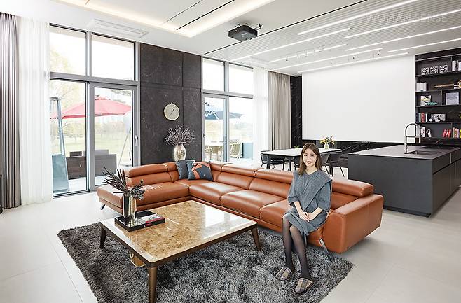 온 가족이 함께 보내는 시간이 가장 많은 거실은 높은 층고와 개방감 있는 창문, 그리고 주방과 경계를 두지 않은 탁 트인 공간감에 신경 써서 꾸몄다. 자칫 밋밋할 수 있는 넓은 공간에 무게감으로 포인트를 주기 위해 선택한 벽은 브라운스톤의 이탈리아 세라믹 브랜드 라미남의 NERO GRECO BOCC와 CALACATTA ORO로 그레이&화이트 무드를 완성했다. 또한 아이들이 함께 머무는 공간이기에 삼화페인트의 아이생각 데코텍스 V.P를 사용해 안전성을 더했다. 남편의 최애템인 대형 식탁은 돌담가구에서 주문 제작했다.