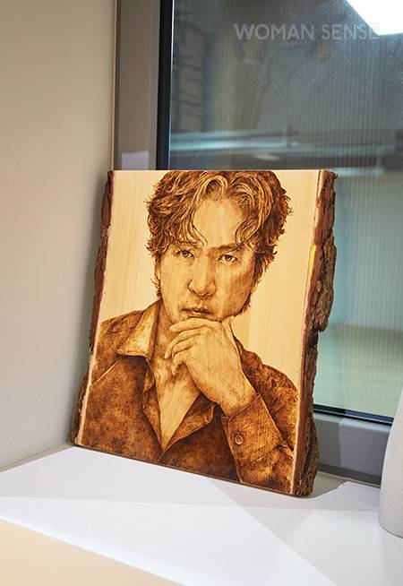 지하로 내려가는 계단에 놓인 남편 얼굴이 새겨진 나무 액자는 암묵적으로 남편의 공간임을 위트 있게 표시하는 상징과도 같다.