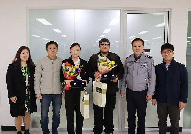 지난달 3일 오후 경기 성남시 야탑동 BYC 빌딩 화재 당시 현장에서 인명 피해를 막은 이수지씨와 신동주씨(왼쪽에서 세번째와 네번째)가 경찰로부터 감사패를 수여받은 후 기념촬영을 하고 있다. /분당경찰서
