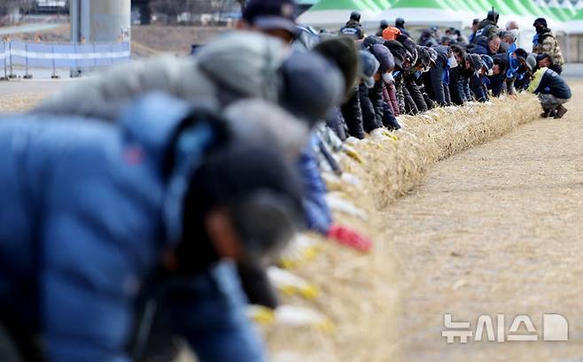 [청도=뉴시스] 이무열 기자 = 6일 오후 경북 청도군 청도천 둔치에서 군민들이 ‘2025 정월대보름 민속한마당’에 사용될 도주줄당기기 가닥줄을 엮고 있다. 2025.02.06. lmy@newsis.com