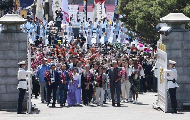 윤석열 대통령이 취임한 2022년 5월 10일 열린 청와대 개방 행사에서 국민 대표 74명이 꽃가지를 들고 입장하고 있다. 뉴시스