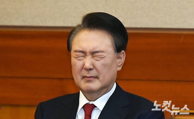 윤석열 대통령이 6일 오전 서울 종로구 헌법재판소 대심판정에서 열린 탄핵심판 6차 변론기일에 출석해 눈을 질끈 감고 있다. 사진공동취재단