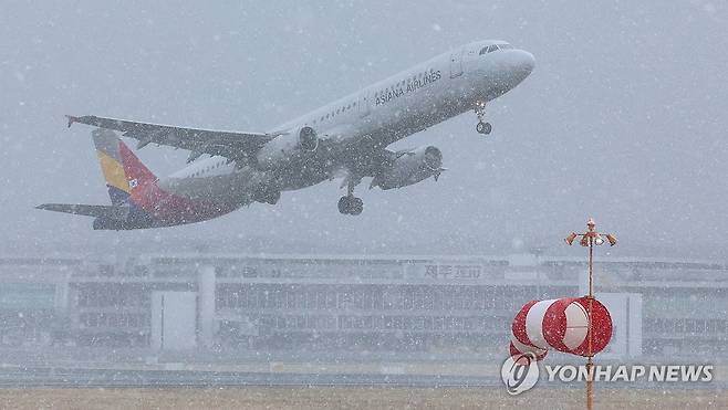 눈보라 뚫고 이륙 (제주=연합뉴스) 박지호 기자 = 7일 제주공항에 강풍경보와 급변풍경보가 발효된 가운데 타지역 폭설 영향까지 겹쳐 결항한 항공편들이 속출하고 있다.
    이날 오후 제주공항 활주로에서 눈보라를 뚫고 항공기가 이륙하고 있다. 2025.2.7 jihopark@yna.co.kr
