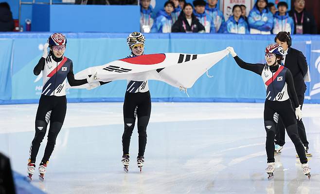 8일 중국 헤이룽장성 하얼빈 빙상훈련센터 다목적홀에서 열린 ‘2025 하얼빈 동계 아시안게임’ 쇼트트랙 여자 500m 결승에서 최민정, 김길리, 이소연이 차례대로 결승선을 통과한 뒤 태극기를 들고 환호하고 있다. 하얼빈=뉴스1