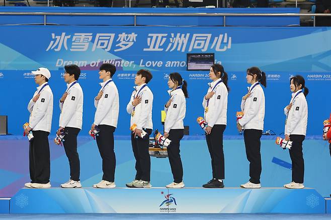 중국 하얼빈 헤이룽장 빙상훈련센터 다목적홀에서 열린 하얼빈 동계아시안게임 쇼트트랙 혼성 2000m 계주 시상식에서 금메달을 차지한 대한민국 선수들이 국기에 경례하고 있다. 사진 | 연합뉴스