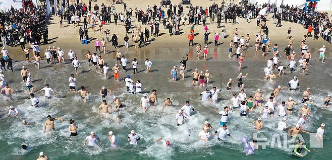 [부산=뉴시스] 하경민 기자 = '제38회 부산 북극곰 축제'가 열린 9일 부산 수영구 광안리해수욕장에서 시민과 관광객 등 인간 북극곰들이 차가운 겨울바다에 뛰어들고 있다. (사진=부산일보 제공) 2025.02.09. yulnetphoto@newsis.com *재판매 및 DB 금지