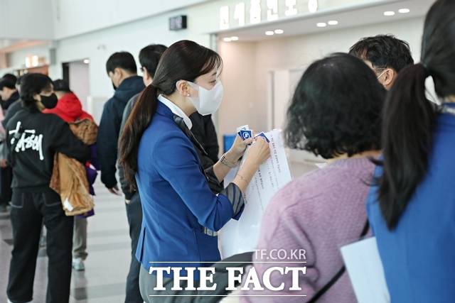 지난 7일 에어부산 직원이 BX146편 탑승객을 대상으로 탑승구 앞에서 휴대 수하물 내 배터리 소지 유무 확인과 배터리 선반 보관 금지 안내 후 노 배터리 인사이드(NO BATTERY INSIDE) 스티커를 부착하고 있다. /에어부산