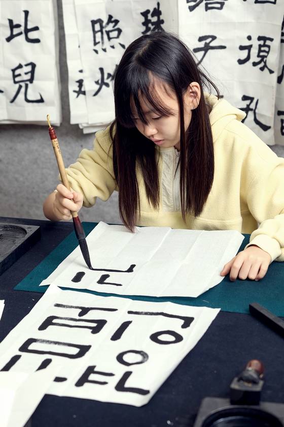 족자에 새해 결심을 쓰기 전, 자신의 이름을 판본체로 쓰면서 연습 중인 김보경 학생기자.