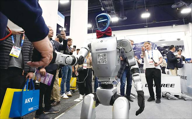 중국 유니트리 H1 로봇이 지난 1월 8일 미국 라스베이거스에서 열린 CES에서 참석한 사람과 악수하고 있다. (로이터=연합뉴스)