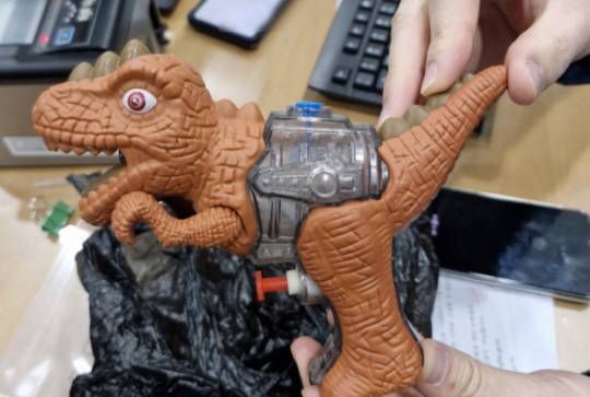 지난 10일 부산 기장군 일광읍의 한 은행에서 30대 남성이 검은 비닐로 감싼 장난감 공룡 물총으로 돈을 내놓으라고 협박하다 고객과 은행 직원에게 2분 만에 검거됐다. 범행에 사용된 장난감 공룡 물총. 연합뉴스