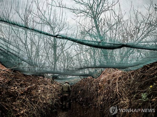 드론 차단용 그물망이 쳐진 참호에서 주변을 살피는 우크라이나군 병사 [EPA 연합뉴스 자료사진. 재판매 및 DB 금지]