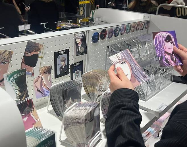 '입학용병' 팝업스토어를 찾은 한 방문객이 포토카드 굿즈를 살펴보고 있다.ⓒ데일리안 이주은 기자